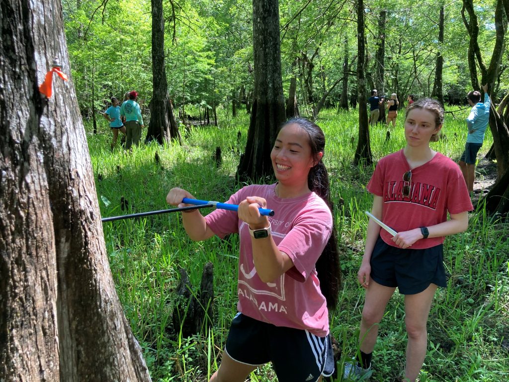 Two girls taking a sample from a tree.