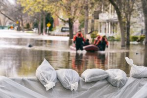 Sand bags on top of a barricade blocking flood waters.