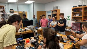  REU students meeting with faculty at the Dauphin Island Sea Lab, standing together in the facility.