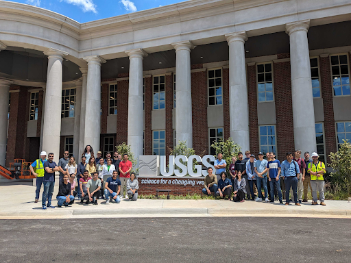 Group by the USGS sign in front of a columned building