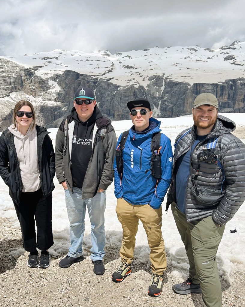 Four water science researchers standing in front of a glacier in Italy.