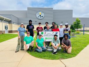 REU students posing outside of the Alberta School of Performing Arts, with the school and garden behind them.