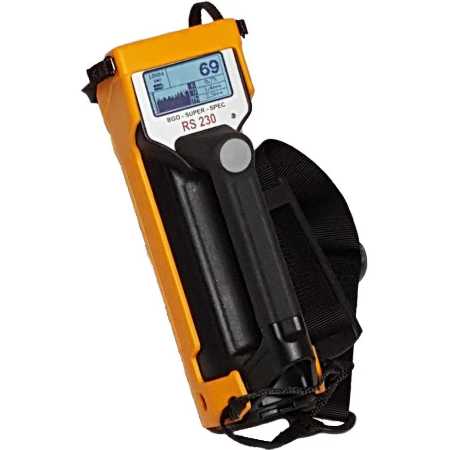 RS-230 handheld gamma-ray spectrometer in yellow casing with digital display and strap, used for measuring natural radioactivity in field samples.