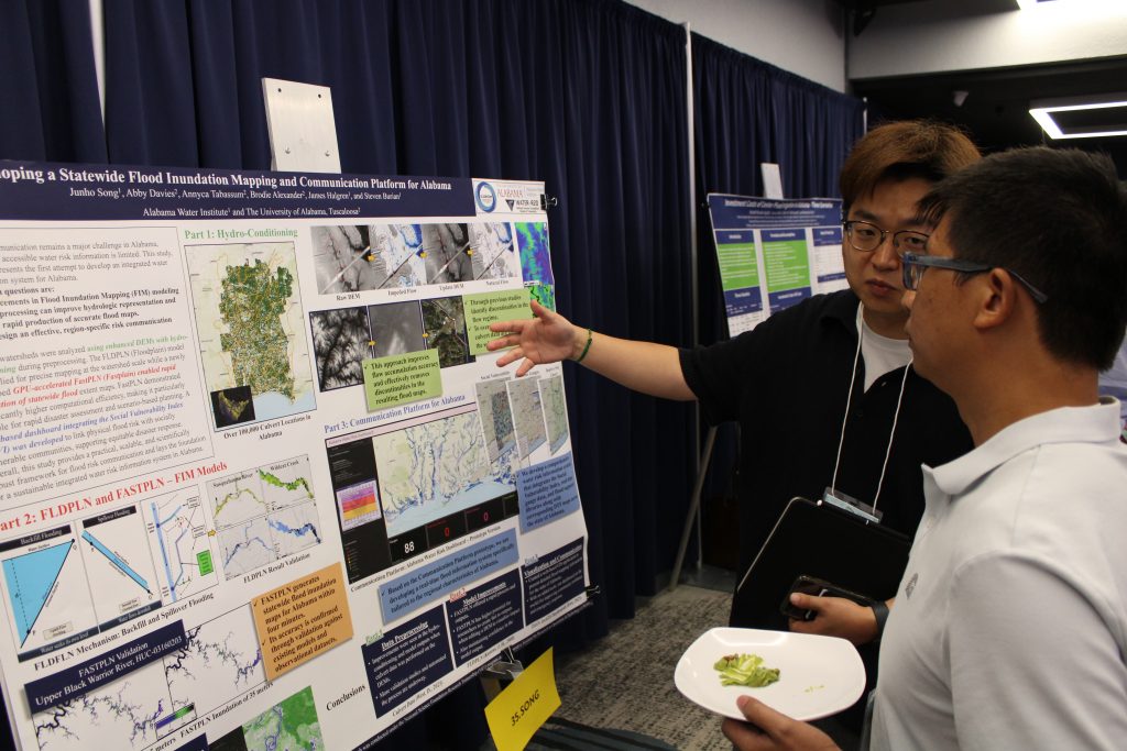 Presenters standing in front of their posters discussing their research.