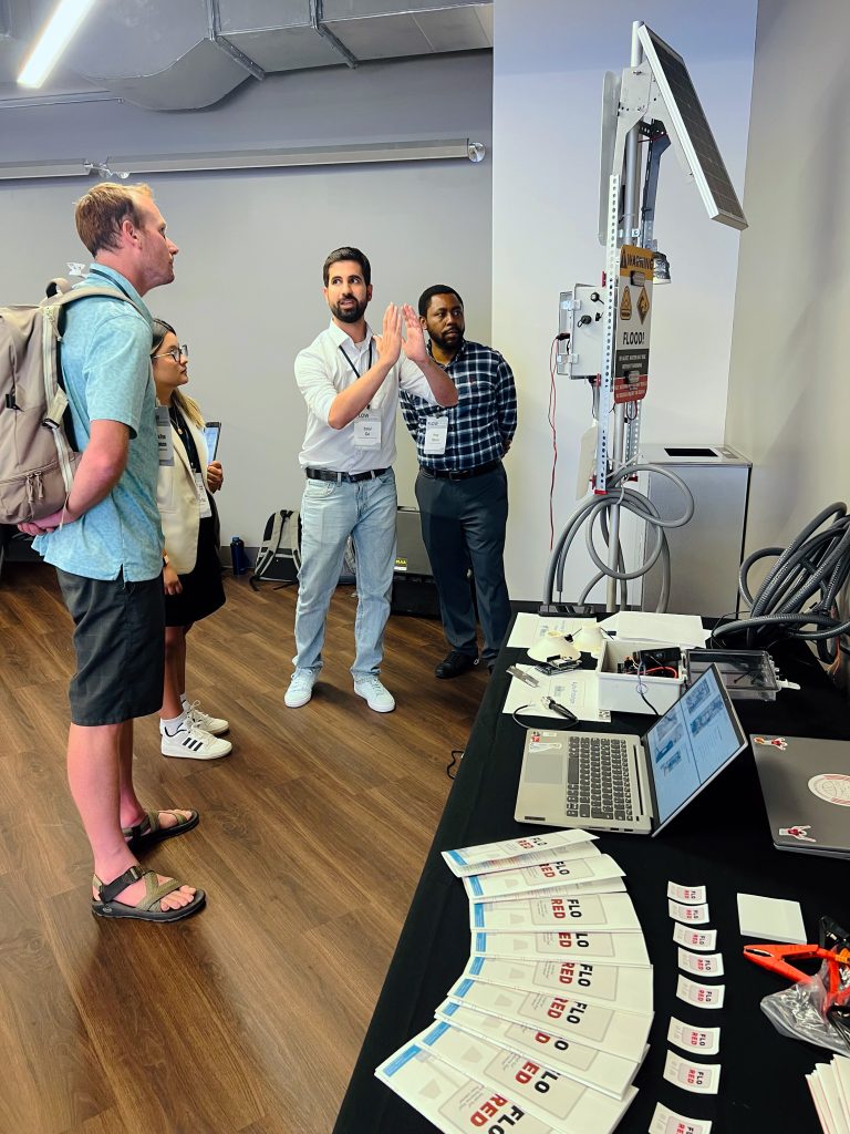 UA FLOW Academy students at Tech Showcase sharing project displays with audience.