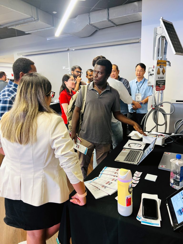 UA FLOW Academy students at Tech Showcase sharing project displays with audience.