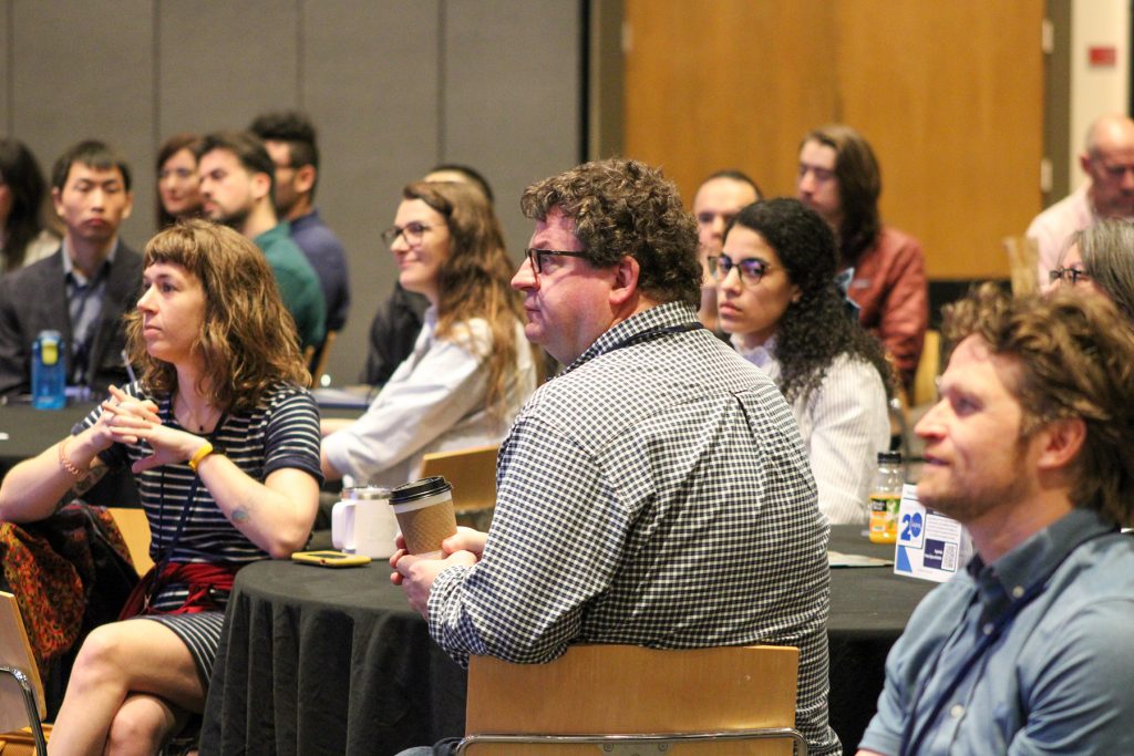 People in crowd watching presentations.