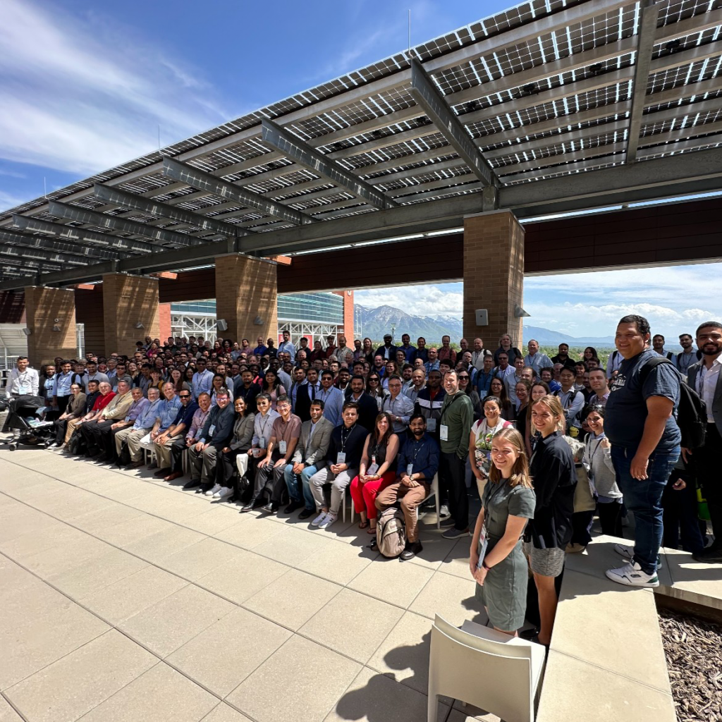 Large group photo of CIROH Developers Conference attendees standing and sitting outdoors with mountains in the background.