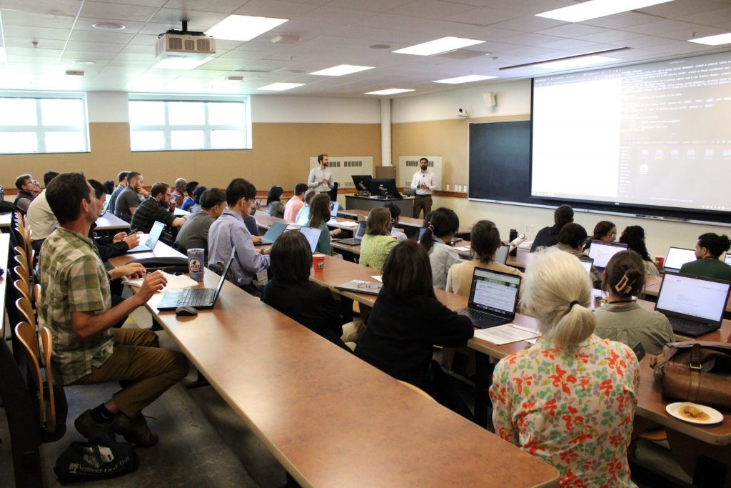 A classroom filled with conference attendees engaging with a presenter-led workshop.