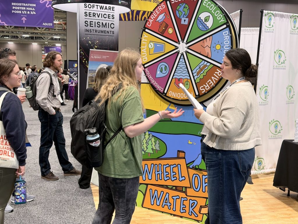 A participant answers a question while standing in front of the Wheel of Water interactive display.
