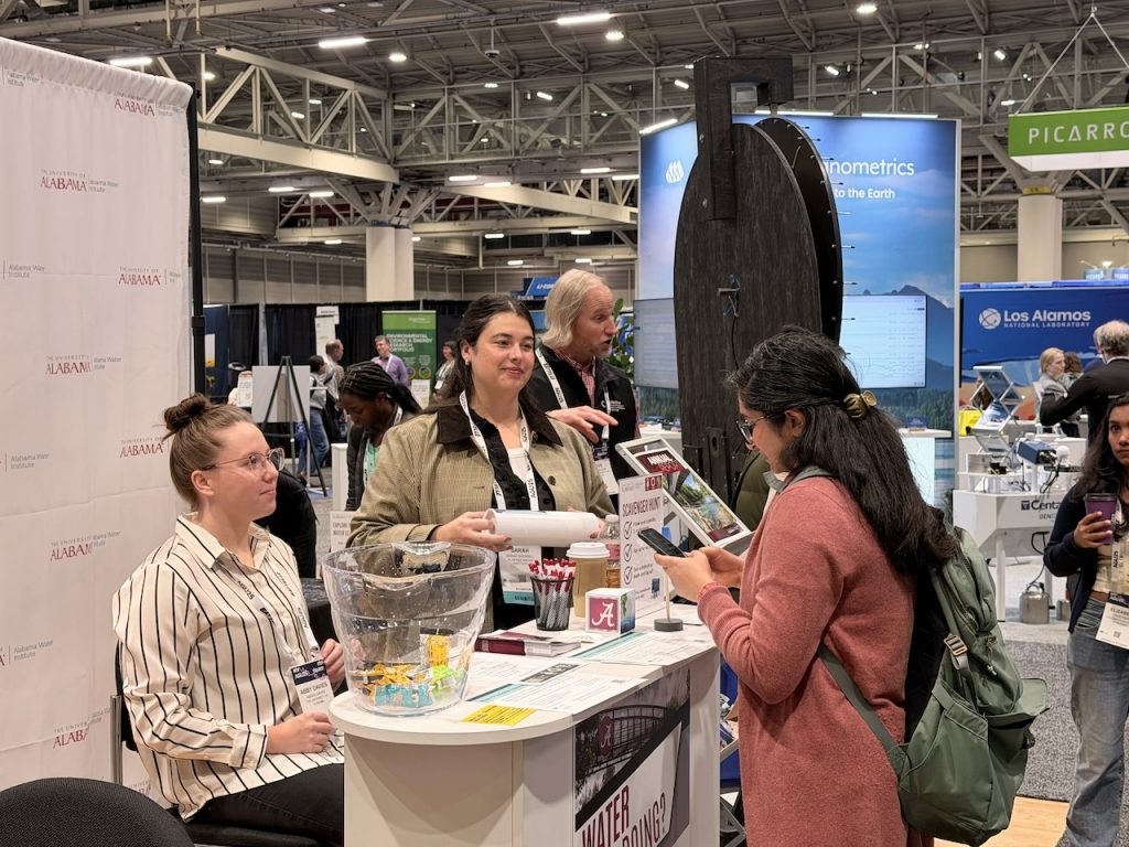 Groups of attendees engage in conversation around the CIROH booth, highlighting the energy of the exhibit floor.